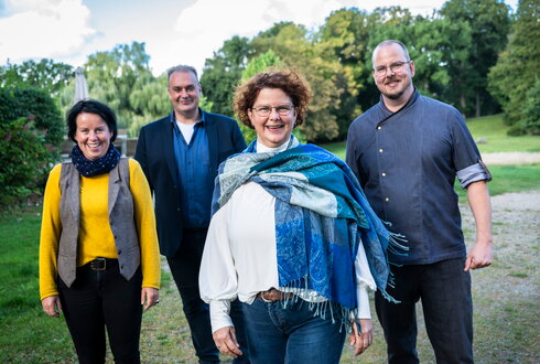 Schloss Kaarz Team lacht in die Kamera im Schloss Park