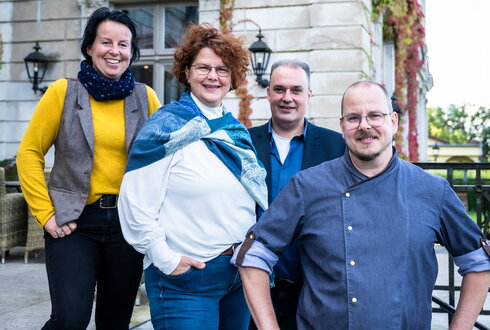 Team von Schloss Kaarz auf der Terrasse schaut freundlich in die Kamera