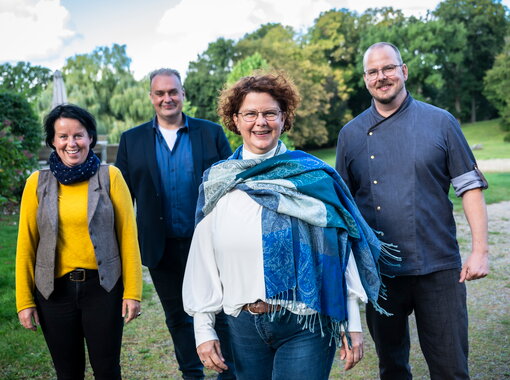 Schloss Kaarz Team lacht in die Kamera im Schloss Park